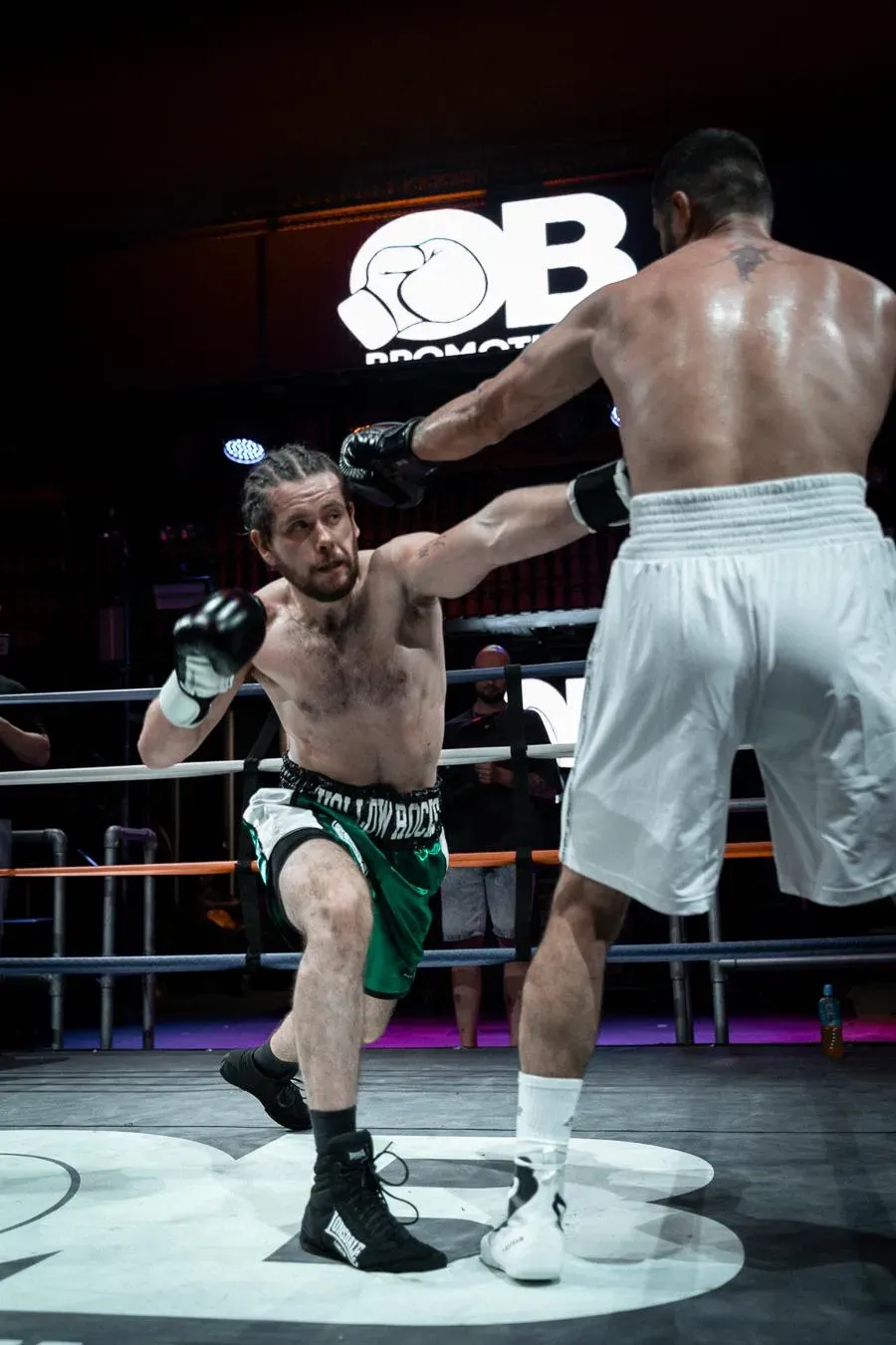 Fighters exchanging blows under arena lights at an OB fight night